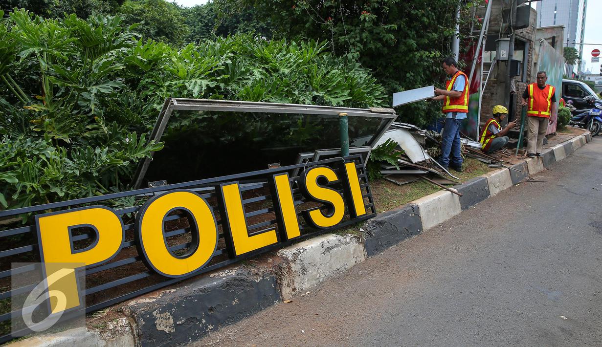 Pekerja mulai merenovasi pos Polisi Sarinah, Jakarta, Jumat (15/1/2016). Pasca teror bom di Pos Polisi Sarinah yang hancur, mulai dibersihkan dan diperbaiki. (Liputan6.com/Faizal Fanani)
