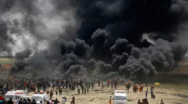 Kepulan asap hitam membubung di pagar perbatasan Palestina-Israel di kota Gaza tengah (13/4). Ratusan warga Palestina membakar ban saat melakukan unjuk rasa di perbatasan Palestina-Israel. (AFP/Mohammed Abed)