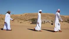Mantan penduduk Wadi al-Murr berjalan dekat rumah-rumah terlantar di Desa Omani, Wadi al-Murr, Oman, 31 Desember 2020. Pasir yang menggunung hanya menyisakan sedikit bukti bahwa Desa Omani pernah ada di Wadi al-Murr, Oman. (MOHAMMED MAHJOUB/AFP)