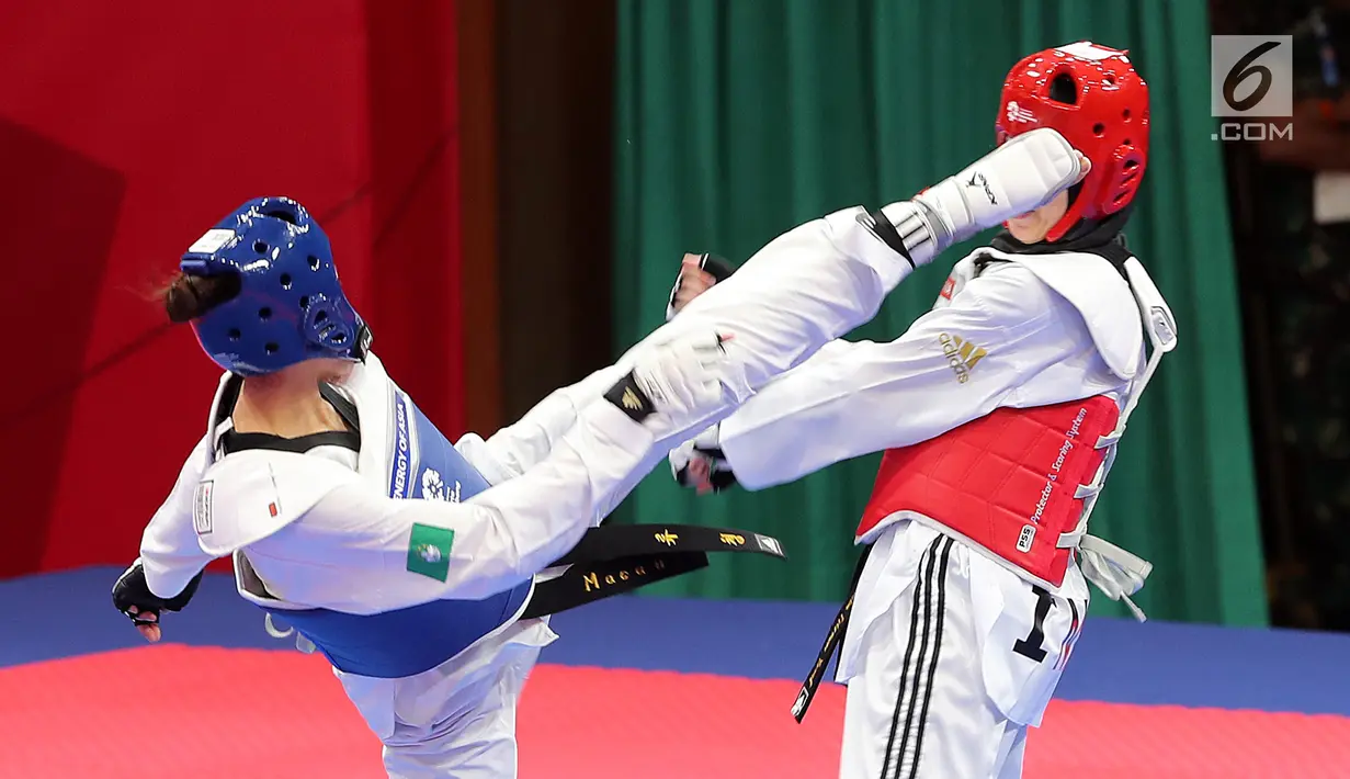 Atlet taekwondo putri Makau, Liu Qing melayangkan tendangannya ke arah Fitriyana Yusuf dari Indonesia pada babak 16 besar di Jakarta Convention Center (JCC), Senin (20/8). Fitriyana kalah tipis 21 - 25 pada kelas Wanita 67 kg. (Liputan6.com/Fery Pradolo)