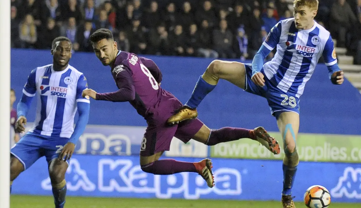 Duel pemain Wigan, Jay Fulton (kanan) dan pemain Manchester City, Ilkay Gundogan (tengah) pada laga babak kelima Piala FA di DW Stadium, Wigan, (19/2/2018). Manchester City kalah 0-1.  (AP/Rui Vieira)