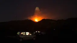 Warga menyaksikan Gunung Etna mengeluarkan lava panas saat meletus di pulau selatan Sisilia, Italia, Senin (7/12). Gunung berapi tertinggi di Eropa itu kembali memuntahkan abu vulkanik setelah dua tahun tidak ada aktivitas. (REUTERS/Antonio Parrinello)