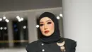 Aksen belt dan bros sebagai pemanis menambah impresi mewah pada penampilan penyanyi 49 tahun itu. Disempurnakan dengan pulasan makeup flawless dan tatanan hijab yang diikat rapi ke belakang. [@rezaartameviaofficial].