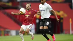 Gelandang Manchester United, Juan Mata mengontrol bola dari kawalan pemain LASK, Andres Andrade pada pertandingan leg kedua babak 16 besar Liga Europa di Stadion Old Trafford, Inggris (6/8/2020). MU menang 2-1 atas Lask dan melaju ke perempat final.  (AP Photo/Dave Thompson)