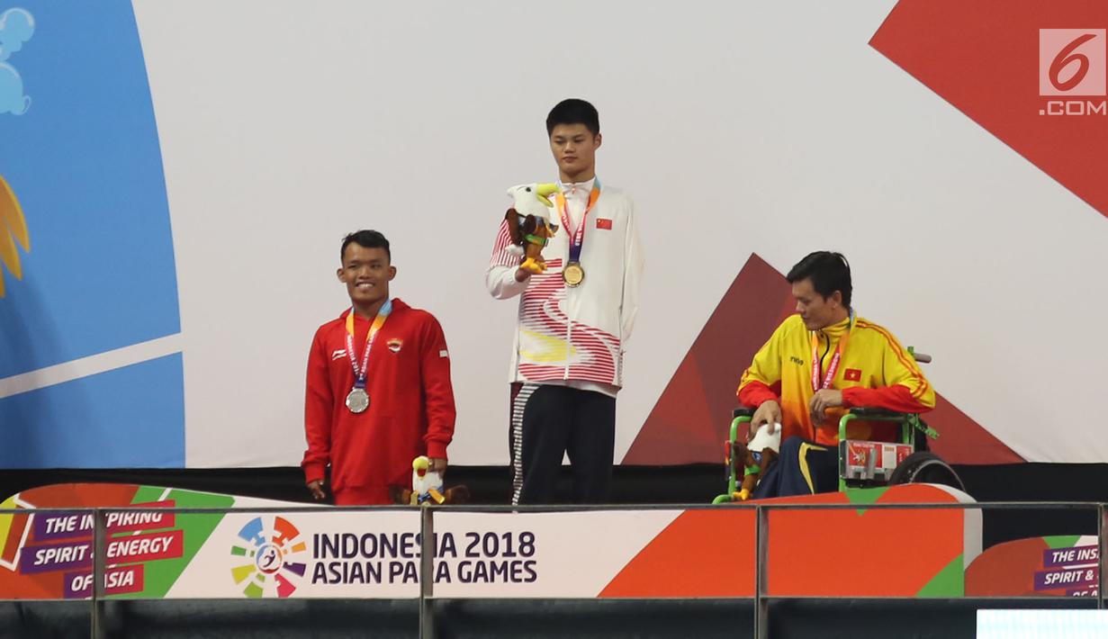 Atlet Indonesia Aris Wibawa saat penyerahan mendali dalam babak final putra 100 meter gaya dada SB7 para renang Asian Para Games 2018 di Aquatic Center, GBK, Jakarta, Senin (8/10). Aris berhasil meraih perak dalam kelas tersebut. (Merdeka.com/Imam Buhori)