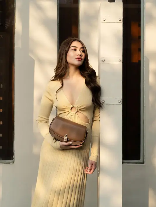 Di sini, Aaliyah Massaid tampil dengan dress beraksen cut-out di bagian depan. Dress ini memiliki detail lengan panjang dan garis leher yang dalam. [Foto: Instagram/aaliyah.massaid]