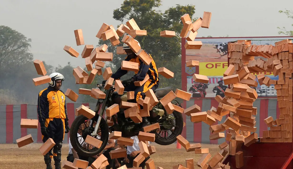 Seorang anggota tentara India dari tim motor 'Tornado' menabrak batu bata selama latihan gabungan di akademi pelatihan perwira di Chennai (9/3). (AFP Photo/Arun Sankar)