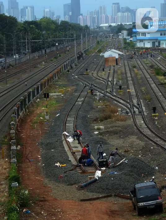 Pekerja menyelesaikan pengerjaan rangkaian rel di Depo Cipinang, Jakarta, Sabtu (16/11/2019). Proyek pembangunan Double-Double Track yang rampung pada awal 2019 masih dalam perbaikan di lajur Depo Cipinang. (merdeka.com/Imam Buhori)