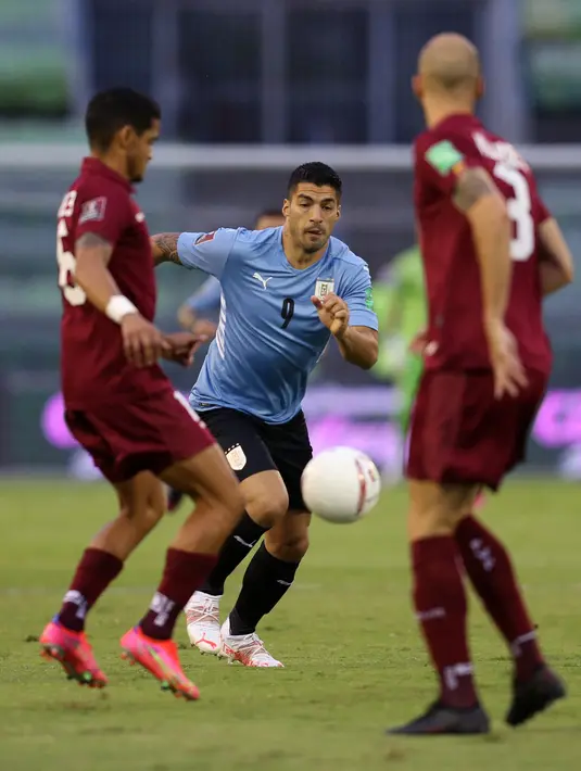 Penyerang timnas, Uruguay Luis Suarez berebut bola dengan pemain Venezuela, Roberto Rosales dan Mikel Villanueva dalam lanjutan kualifikasi Piala Dunia 2022 di Stadion Olimpico de la UCV, Caracas, Rabu (9/6/2021) pagi WIB. Uruguay ditahan imbang tanpa gol oleh Venezuela. (MANAURE QUINTERO/POOL/AFP)