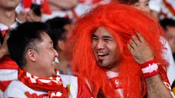 Seorang fans mengenakan rambut palsu tertawa dengan rekannya sebelum pertandingan antara Rusia dan Jepang pada pembukaan Rugby World Cup Pool A  di Stadion Tokyo (20/9/201). Rugby World Cup diselenggarakan dari 20 September hingga 2 November 2019. (AFP Photo/Toshifumi Kitamura)