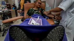 Seorang tentara mendonorkan darahnya setelah penembakan brutal di Korat, Nakhon Ratchasima, Thailand, Minggu (9/2/2020). Petugas keamanan berhasil menembak mati pelaku penembakan brutal tersebut. (AP Photo/Gemunu Amarasinghe)