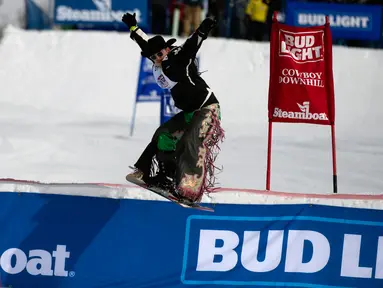 Seorang koboi asal Delts, Hunter Brasfield melompat di atas papan luncur pada turnamen Cowboy Downhill ke-46 di Steamboat Springs, Colorado, 20 Januari 2020. Para koboi yang biasa menunggangi kuda atau banteng ini ditantang untuk meluncur menggunakan papan ski dan snowboard. (Jason Connolly/AFP)