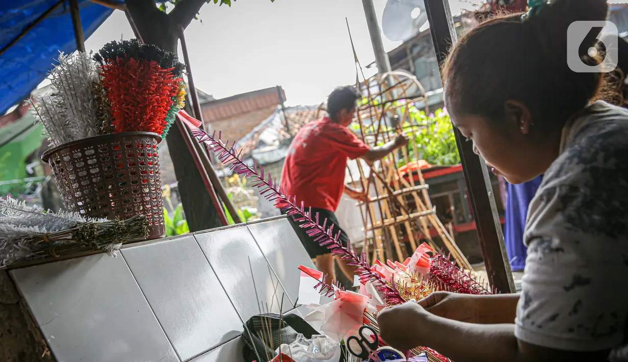 Perajin menyelesaikan aksesoris Ondel-ondel di Kramat Pulo, Jakarta, Senin (7/6/2021). Harga ondel-ondel tersebut mencapai Rp. 5 juta untuk sepasangnya. (Liputan6.com/Faizal Fanani)