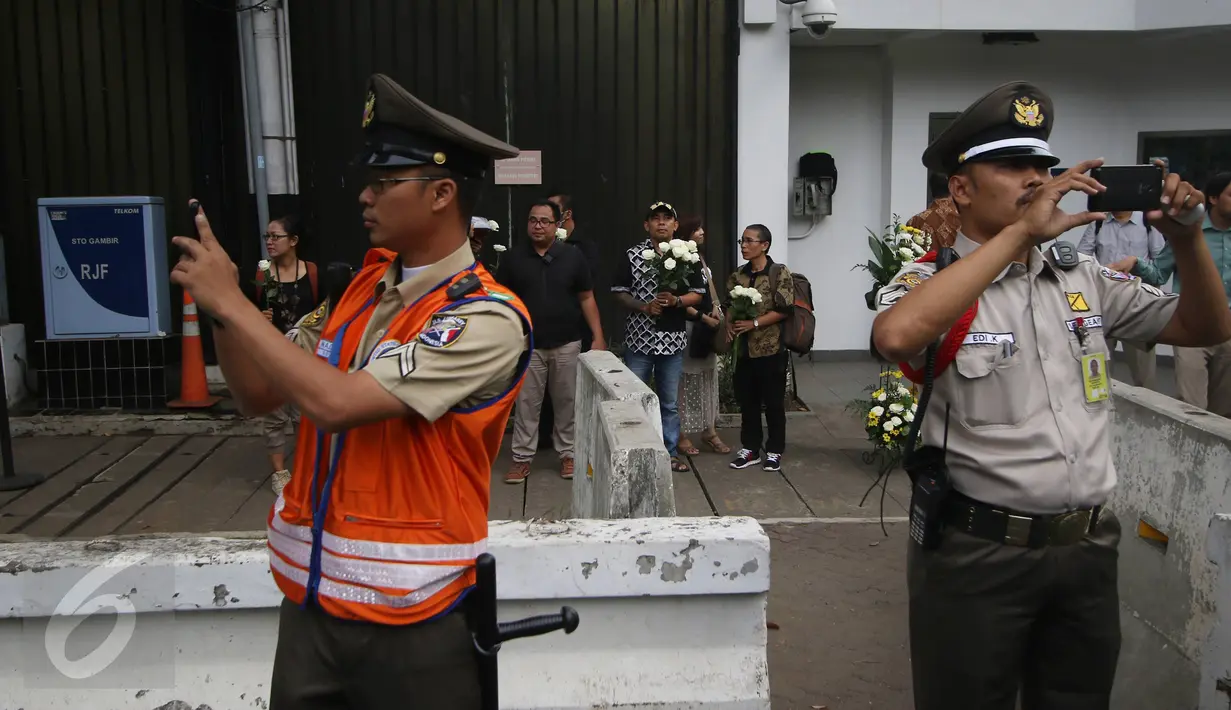 Petugas keamanan melarang wartawan untuk mengambil gambar di depan Kantor Kedubes AS, Jakarta, Selasa (14/6). wartawan mengalami kesulitan untuk meliput aksi simpatik yang dilakukan komunitas GKSI. (Liputan6.com/Immanuel Antonius)