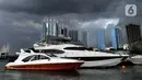 Kapal-kapal bersandar saat awan cumulonimbus menyelimuti perairan Teluk Jakarta, Minggu (10/1/2021). Sejak beberapa hari terakhir, perairan Teluk Jakarta diselimuti cuaca ekstrem yang berbahaya bagi pelayaran dan penerbangan. (merdeka.com/Arie Basuki)