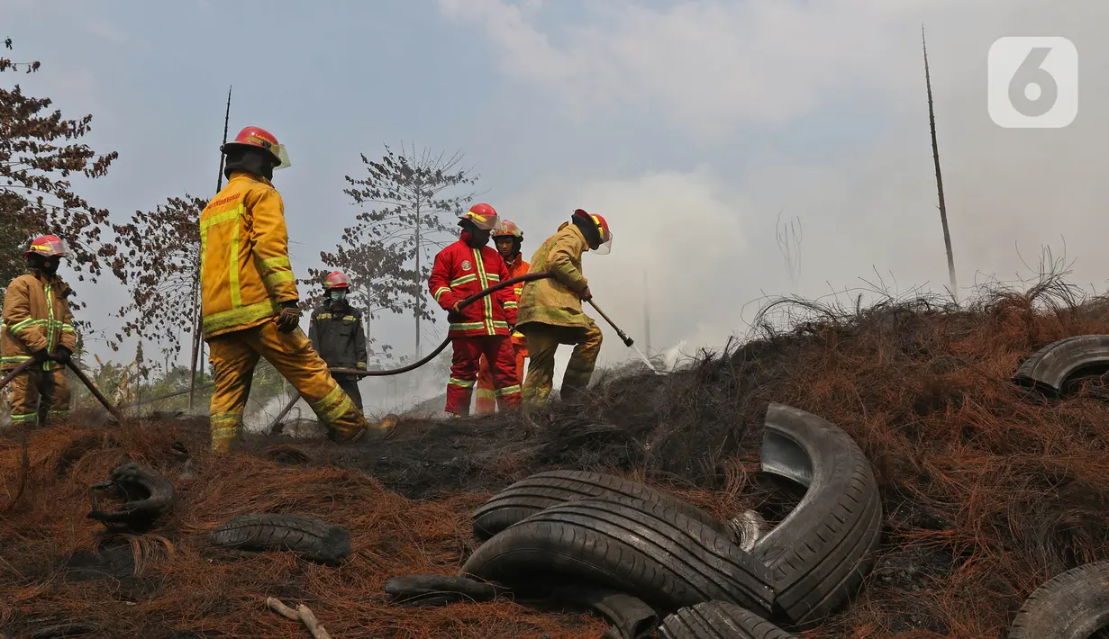 Petugas Pemadam Kebakaran Kabupaten Bogor memadamkan api di lapak ban bekas, Desa Bojong Nangka, Gunung Putri, Kamis (22/4/2021). Kebakaran lapak ban bekas yang terjadi Senin (19/4) petang tersebut hingga saat ini belum bisa dipadamkan. (Liputan6.com/Herman Zakharia)