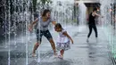 Warga bermain diantara air mancur saat menikmati musim panas di taman Gorky, Moskow, Rusia, Minggu (9/8/2015). (REUTERS/Sergei Karpukhin)