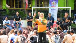 Seorang guru SMAN 3 Kota Malang selfie dengan latar belakang pemain Arema. Sabtu (30/4/2016).(Bola.com/Iwan Setiawan)