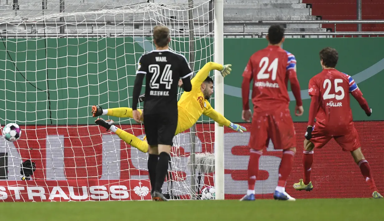 Kiper tim Divisi 2 Holstein Kiel, Ioannis Gelios  gagal mengantisipasi tendangan penalti dari gelandang Bayern Munich, Leory Sane dalam laga babak kedua Piala DFB Pokal 2020/21 di Kiel, Rabu (13/1/2021). Holstein Kiel menang atas Bayern Munich lewat adu penalti 5-6 (2-2). (AFP/Fabian Bimmer/Pool)
