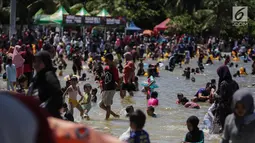 Sejumlah anak bermain air di pantai Ancol, Jakarta, Senin (25/12). Pengunjung lebih memilih liburan ke Pantai Ancol karena gratis, tidak dikenai biaya tambahan. (Liputan6.com/Faizal Fanani)