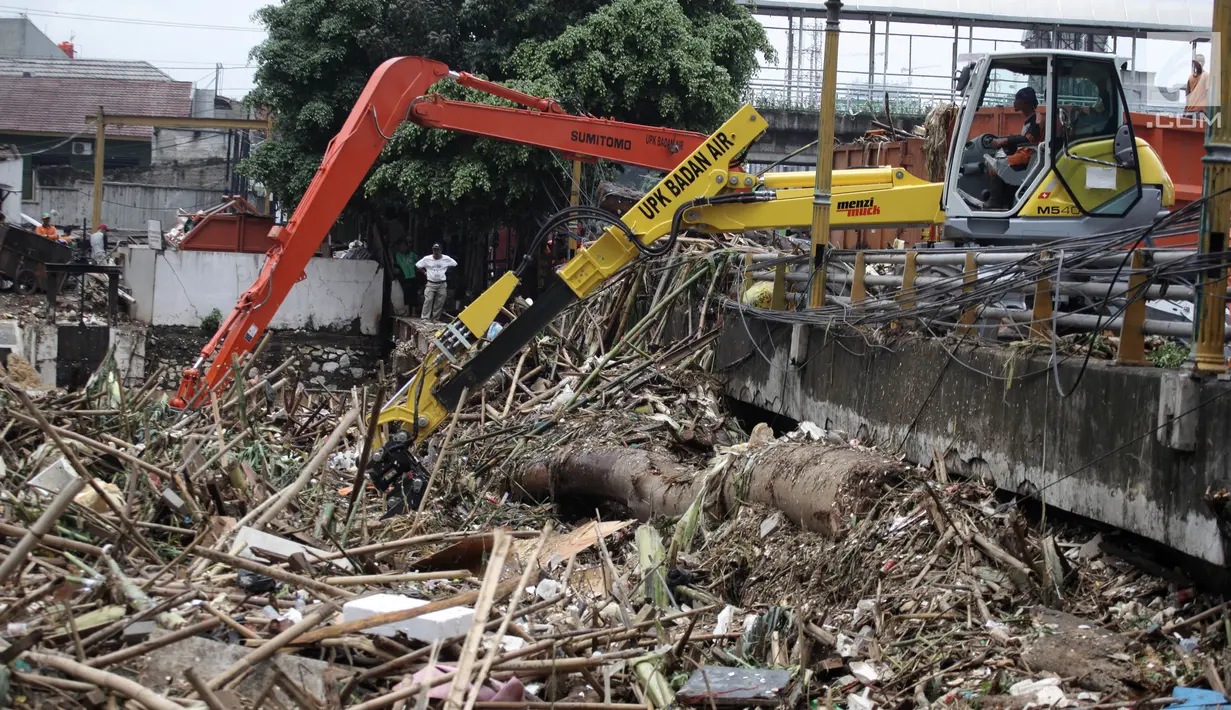 Alat berat mengangkat ratusan ton sampah yang menumpuk di Jembatan Jalan KH Abdullah Syafei, Jakarta, Selasa (6/2). Hingga kini, Dinas Lingkungan Hidup DKI Jakarta telah mengangkut 700 ton sampah. (Liputan6.com/Arya Manggala)