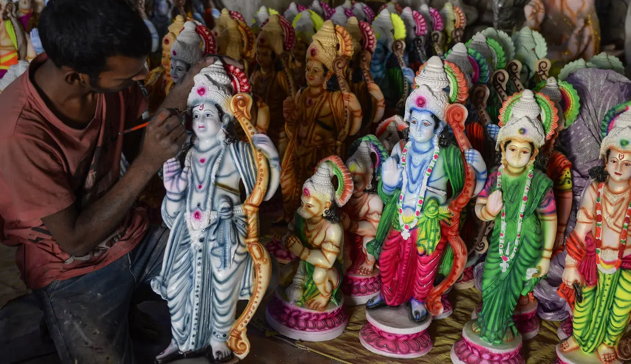 Seorang seniman India mewarnai patung dewa Hindu Rama di sebuah lokakarya di Hyderabad, India (15/3). Para seniman ini membuat patung dewa menjelang festival Rama Navami. (AFP/Noah Seelam)