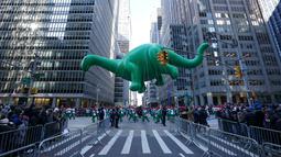 Balon Dino melayang di atas kawasan Sixth Avenue selama Parade Macy's Thanksgiving Day di New York, Kamis (22/11). Balon raksasa berbentuk ikon-ikon kartun terkenal menghiasi gelaran yang digelar untuk ke-92 tersebut. (Don EMMERT / AFP)