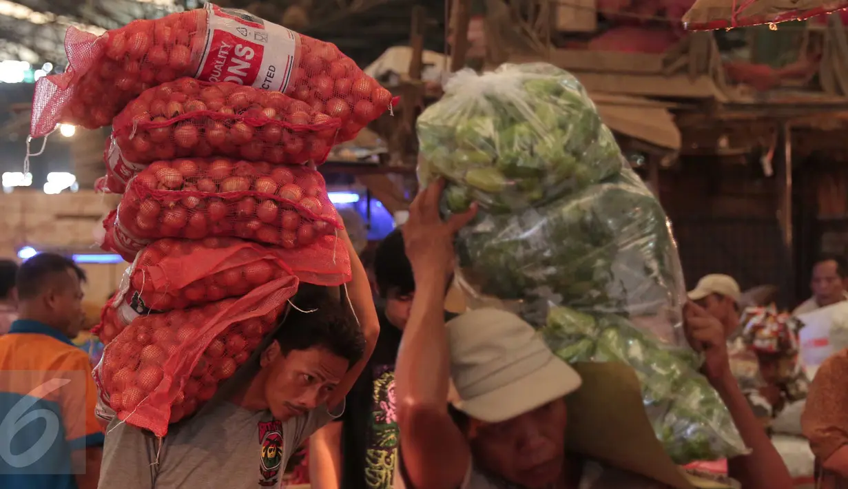 Seorang pria memanggul bawang bombay di Pasar Induk Kramat Jati, Jakarta, Selasa (22/12). Jelang Natal dan tahun baru, harga sayur mayur dan beberapa kebutuhan pokok lainnya di beberapa pasar di Jakarta merangkak naik. (Liputan6.com/Angga Yuniar)