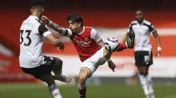 Bek Arsenal, Hector Bellerin (tengah) berebut bola dengan bek Fulham, Antonee Robinson dalam laga lanjutan Liga Inggris 2020/2021 pekan ke-32 di Emirates Stadium, Minggu (18/4/2021). Arsenal bermain imbang 1-1 dengan Fulham. (AP/Julian Finney/Pool)