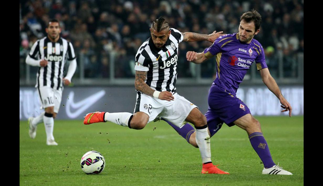 Gelandang Juventus,  Arturo Vidal berusaha melewati pemain Fiorentina Milan Badelj pada leg pertama Semifinal Coppa Italia di stadion Juventus, Turin, Italia (5/3/2015).  Fiorentina Menang 2-1 atas Juventus. (AFP PHOTO/Marco Bertorello)