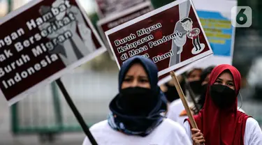 Aktivis yang tergabung dalam Serikat Buruh Migran Indonesia (SBMI) melakukan aksi damai di Kawasan Monas, Jakarta Pusat, Minggu (13/3/2022). Aksi yang diikuti oleh para pekerja perempuan dan mahasiswa ini dilakukan untuk memperingati hari Perempuan Sedunia. (Liputan6.com/Johan Tallo)