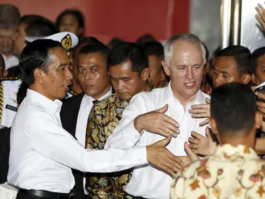 Presiden Indonesia Joko Widodo (kiri) dan Perdana Menteri Australia Malcolm Turnbull (tengah) berjabat tangan dengan pedagang saat blusukan di Blok A Pasar Tanah Abang, Jakarta, Kamis (12/11). (REUTERS/Darren Whiteside)