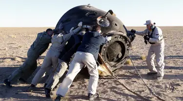 Tim penyelamat bekerja di pendaratan kapsul ruang angkasa Soyuz MS-08 di luar Kota Dzhezkazgan, Kazakhstan, Kamis (4/10). Kapsul berisi astronot NASA Andrew Feustel dan Richard Arnold serta kosmonot Roscosmos Oleg Artemyev. (Maxim Shipenkov/Pool/AFP)