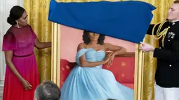 Mantan ibu negara Michelle Obama bersiap mengungkap potret resmi dari lukisannya yang akan menjadi koleksi Gedung Putih di Ruang Timur Gedung Putih, Washington, Rabu (7/9/2022).  Michelle Obama dilukis dengan posisi duduk, dengan mengenakan gaun berwarna biru muda. (AP Photo/Andrew Harnik)