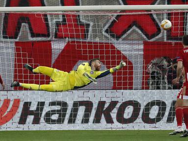 Kiper Olympiakos, Jose Sa kebobolan gol kedua lewat tendangan yang dilepaskan bek Arsenal, Gabriel dalam laga leg pertama babak 16 besar Liga Europa 2020/2021 di Georgios Karaiskakis Stadium, Kamis (11/3/2021). Olympiakos kalah 1-3 dari Arsenal. (AP/Thanassis Stavrakis)