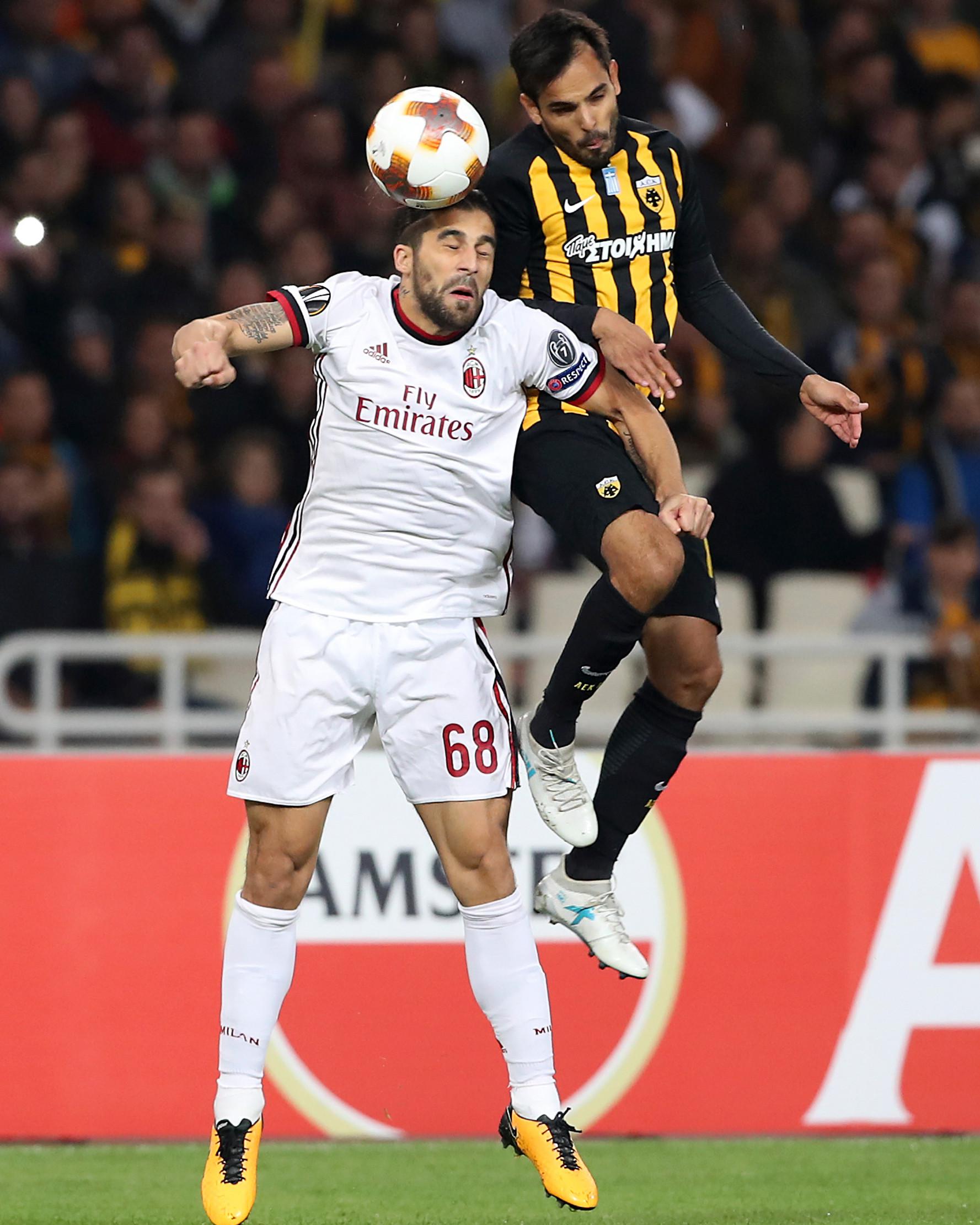 Pemain AC Milan, Ricardo Rodriguez melompat untuk merebut bola dari pemain AEK Athens, Rodrigo Galo pada laga lanjutan Grup D Liga Europa di Stadion Athens Olympic, Jumat (3/11). Milan dan AEK harus puas bermain imbang tanpa gol (AP/Petros Giannakouris)
