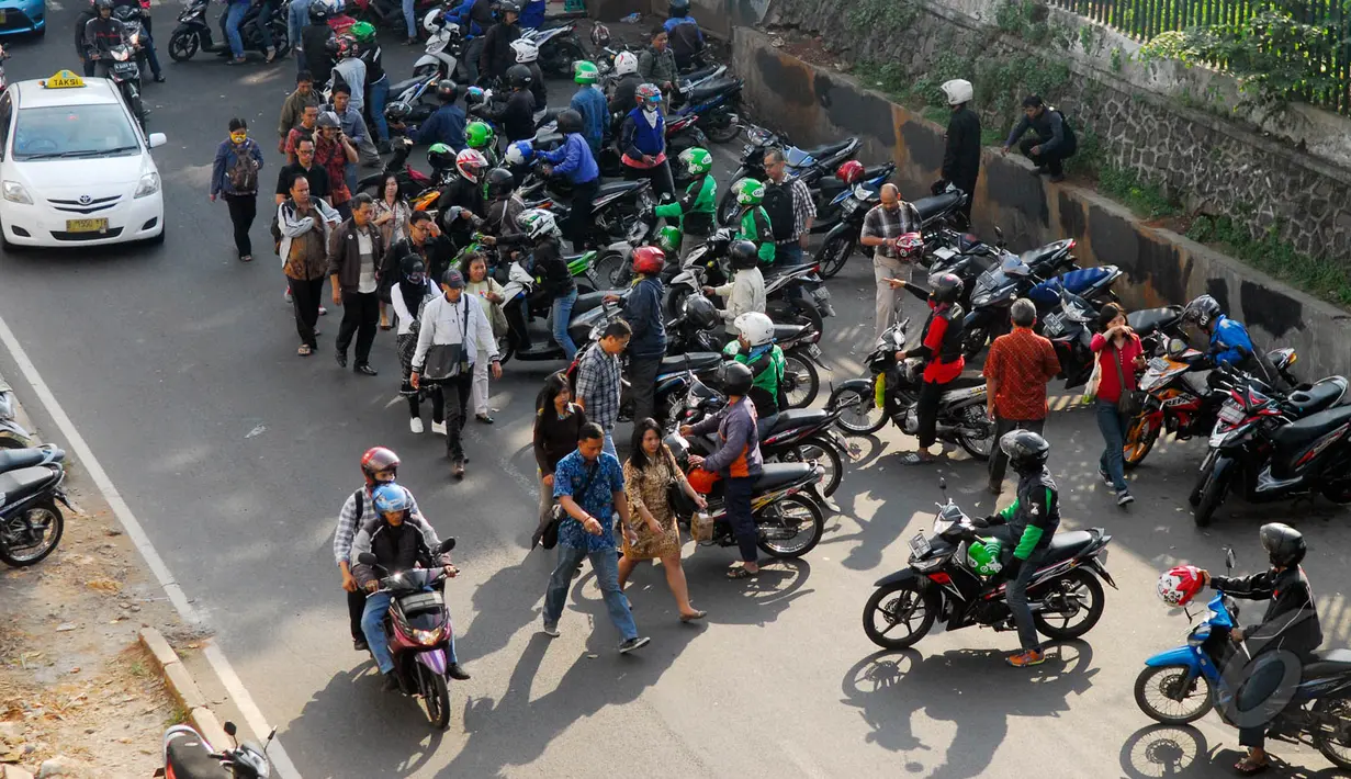 Puluhan tukang ojek berebut penumpang di depan stasiun Palmerah, Jakarta, Jumat (22/5/2015). Rebutan penumpang oleh para tukang ojek ini membuat kemacetan panjang setiap harinya. (Liputan6.com/Johan Tallo) 