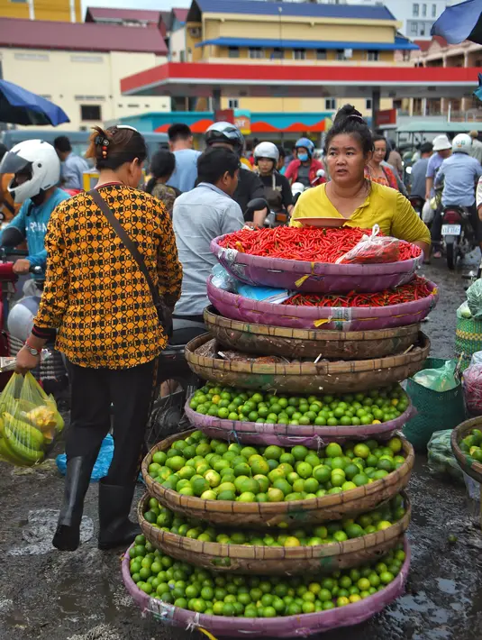 Seorang wanita mendorong troli penuh limau dan cabai di sebuah pasar di Phnom Penh (24/7/2020). Ibu kota Kamboja ini dipenuhi pasar baik besar maupun kecil. (AFP/Tang Chhin Sothy)