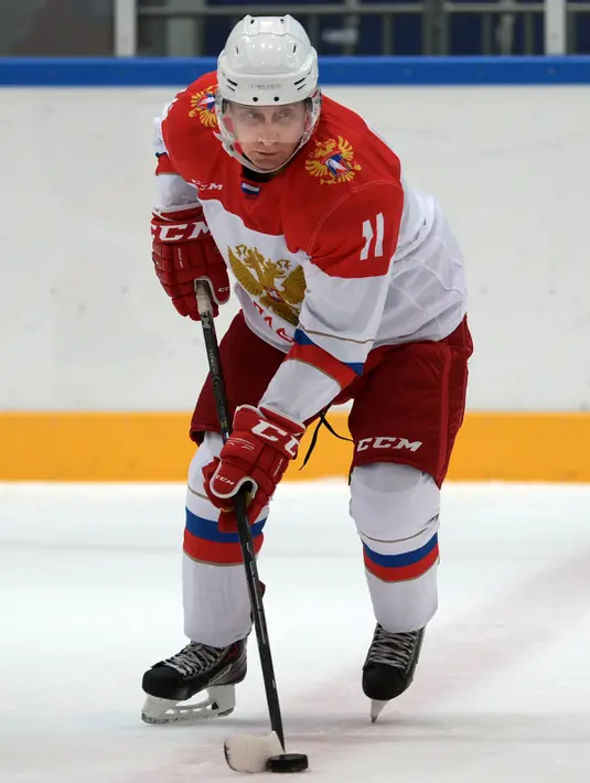 Aksi Presiden Rusia, Vladimir Putin memegang stick pada sesi latihan hoki es disaat perayaan natal umat kristen ortodoks di arena Galaktika, Sochi, Rabu (6/1/2016). (Aleksey NIKOLSKYI/Sputnik/AFP)