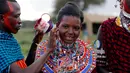 Seorang atlet perempuan, Joyce Tokoyan dilumuri cat merah saat persiapan Olimpiade Masai 2016 di cagar alam Sidai Oleng, kaki Gunung Kilimanjaro dekat perbatasan Kenya-Tanzania (10/12). (Reuters/Thomas Mukoya)
