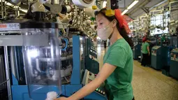 Seorang pekerja wanita saat berkerja di jalur produksi yang membuat kaus kaki pria di Pabrik Kaus Kaki Pyongyang di Korea Utara (24/5/2021). Pabrik telah memastikan bahwa karyawannya meningkatkan keterampilan teknis mereka melalui studi di ruang pembelajaran sci-tech. (AFP/Kim Won Jin)