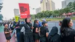 Seorang penonton membawa poster bertema kebakaran hutan dan lahan (karhutla) saat Jakarta Running Festival (JRF) 2026 di sepanjang lintasan Jalan Jenderal Sudirman, Jakarta, Sabtu (24/10/2026). (KLY/Budy Santoso)