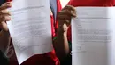 Perwakilan dari Komunitas Suporter Antikorupsi (KORUPSSI) memperlihatkan surat laporan dugaan korupsi PSSI di kantor KPK, Senin (8/6/2015). (Liputan6.com/Helmi Afandi)