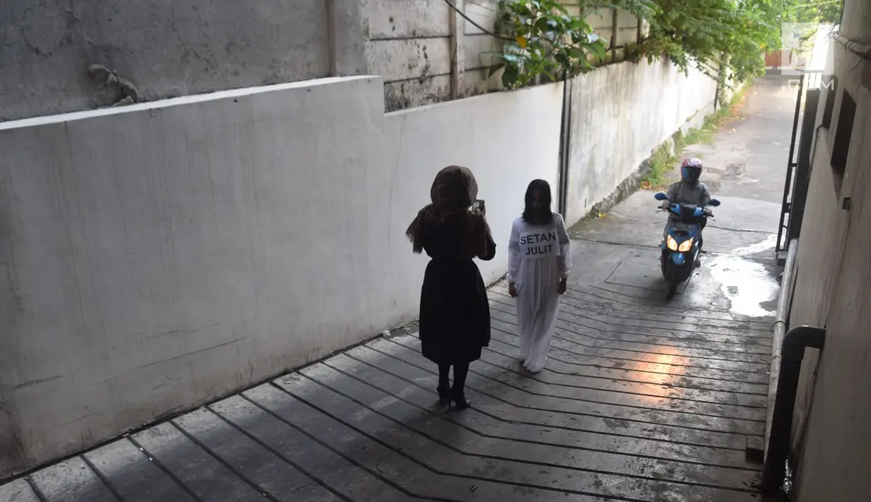 Pengendara motor melintas saat karyawan Star Hotel Semarang mengadakan teatrikal 'merantai setan' di parkiran bawah hotel, Selasa (15/5). Aksi unik yang mengundang perhatian tersbut untuk menyambut bulan Ramadan. (Liputan6.com/Gholib)