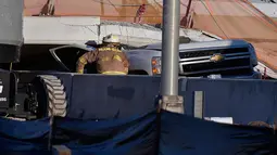 Seorang petugas pemadam kebakaran Miami-Dade Fire Rescue melihat sebuah truk pickup yang tertipa jembatan runtuh di Miami, Florida (15/3). Sedikitnya delapan mobil terjebak dalam reruntuhan jembatan. (Michael Laughlin / South Florida Sun-Sentinel via AP)