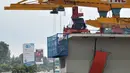 Pekerja menyelesaikan proyek jalan layang Simpang Susun Semanggi, Jakarta, Kamis (23/2). Pembangunan tersebut diharapkan menjadi salah satu upaya mengurai kemacetan di kawasan ini. (Liputan6.com/Yoppy Renato)