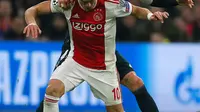 Pemain Ajax Dusan Tadic berebut bola dengan bek Real Madrid, Sergio Ramos pada leg pertama 16 besar Liga Champions di Johan Cruijff ArenA, Amsterdam, Rabu (13/2). Real Madrid harus bersusah payah menaklukkan Ajax dengan skor tipis 2-1. (AP/Peter Dejong)