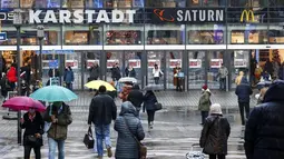 Orang-orang berjalan ke pusat perbelanjaan di pusat Kota Essen, Jerman, Senin (14/12/2020). Jerman melakukan lockdown nasional pada 16 Desember 2020 untuk memerangi pandemi COVID-19. (AP Photo/Martin Meissner)