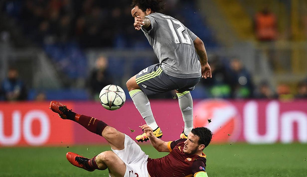 Gelandang Roma, Alessandro Florenzi, terjatuh saat berebut bola dengan bek sayap Real Madrid, Marcelo. Hasil ini membuat peluang Roma lolos kian berat mengingat leg kedua akan berlangsung di Stadion Santiago Bernabeu. (AFP/Filippo Monteforte)