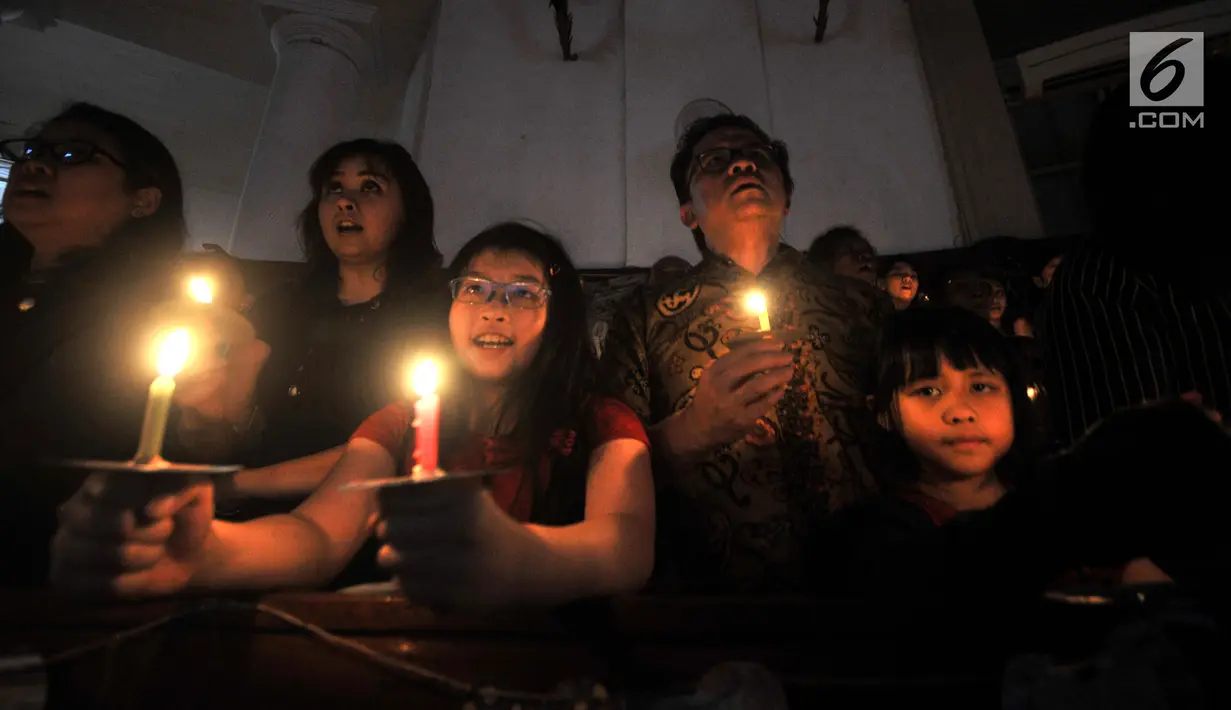 Jemaat memanjatkan doa dengan menyalakan lilin pada Misa Malam Natal di Gereja Immanuel, Jakarta, Senin (24/12). Misa Natal tahun ini mengangkat tema Membangun Spiritualitas Damai yang Menciptakan Perdamaian. (Merdeka.com/Iqbal S. Nugroho)